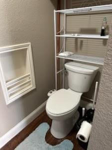 bathroom with hardwood / wood-style flooring and toilet