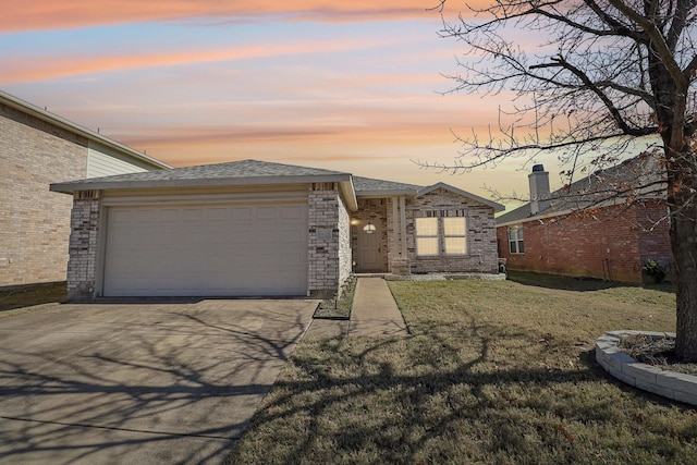 ranch-style house with a garage and a lawn