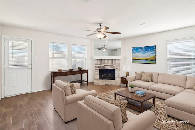 living room featuring ceiling fan, a healthy amount of sunlight, a fireplace, and light hardwood / wood-style floors