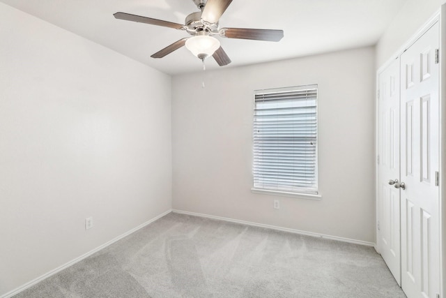 unfurnished room featuring ceiling fan and light carpet