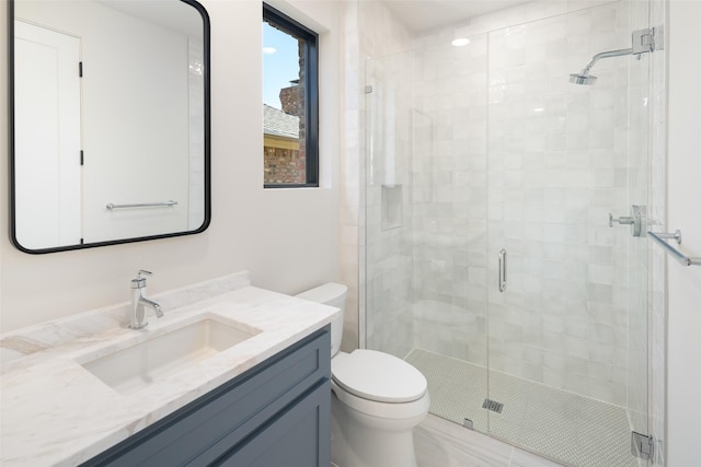 bathroom with vanity, toilet, and a shower with door