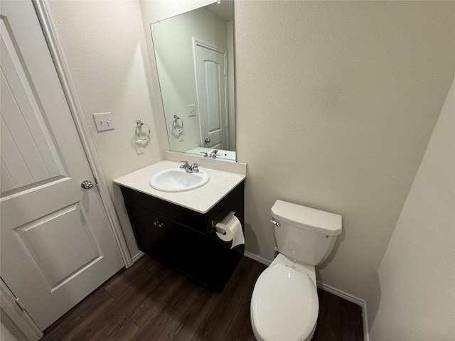 bathroom with hardwood / wood-style floors, vanity, and toilet