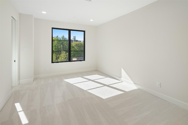 spare room featuring light colored carpet