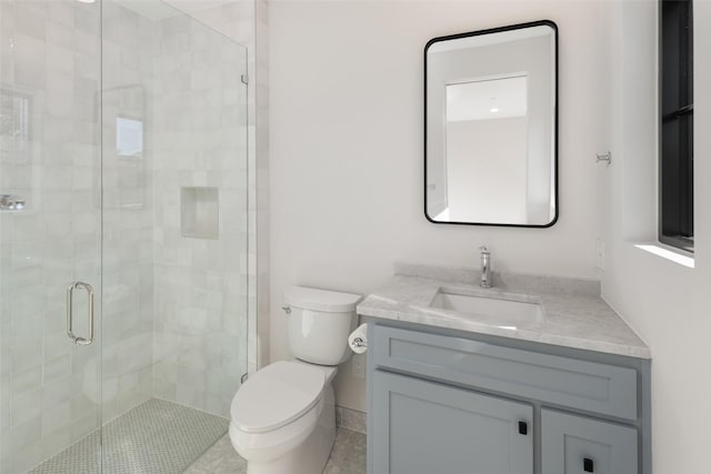 bathroom featuring tile patterned flooring, vanity, toilet, and an enclosed shower