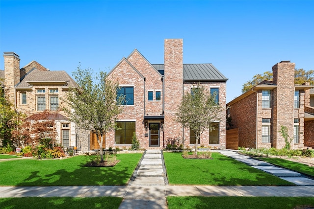 view of front of property featuring a standing seam roof, brick siding, metal roof, and a front lawn