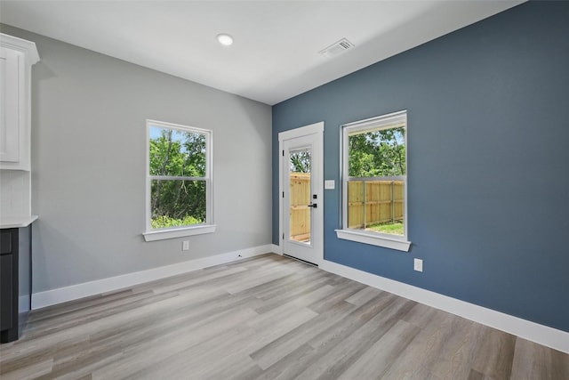 720 W Parnell, Denison, TX 75020 - unfurnished living room with healthy amount of natural light, light wood-type flooring, baseboards, and recessed lighting