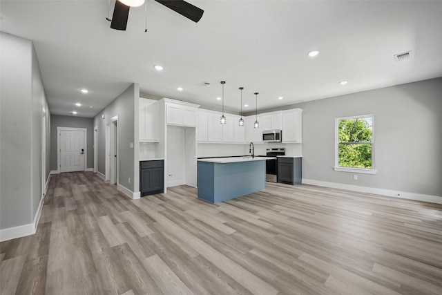 720 W Parnell, Denison, TX 75020 - kitchen with appliances with stainless steel finishes, a sink, a center island with sink, recessed lighting, and ceiling fan