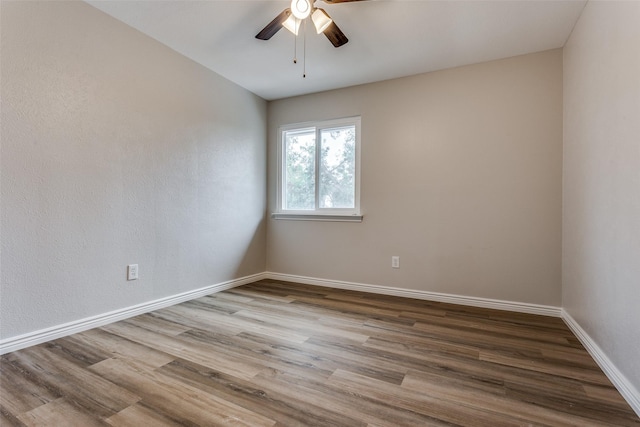 empty room with hardwood / wood-style floors and ceiling fan