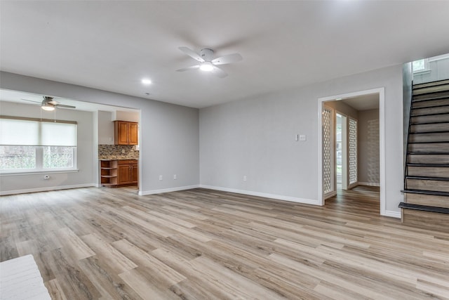 unfurnished living room featuring ceiling fan and light hardwood / wood-style floors