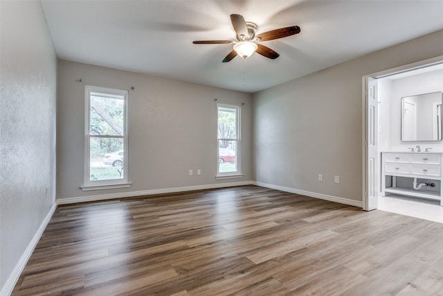 unfurnished bedroom featuring multiple windows, light hardwood / wood-style flooring, and ceiling fan