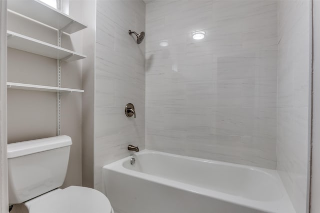 bathroom featuring tiled shower / bath combo and toilet