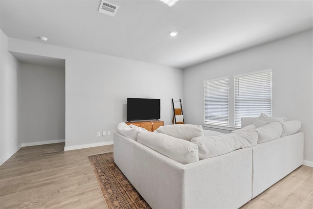 living area featuring light wood-style flooring, visible vents, baseboards, and recessed lighting