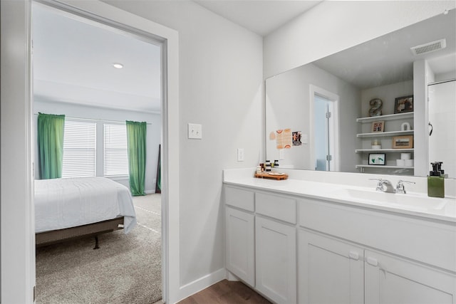 full bath with visible vents, connected bathroom, vanity, and baseboards