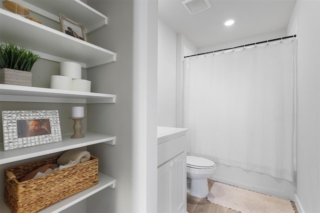 bathroom with toilet, shower / bath combo with shower curtain, and visible vents