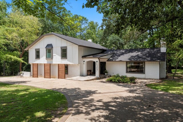 tri-level home featuring a garage and a front yard