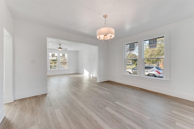 interior space featuring ceiling fan with notable chandelier and light wood-type flooring