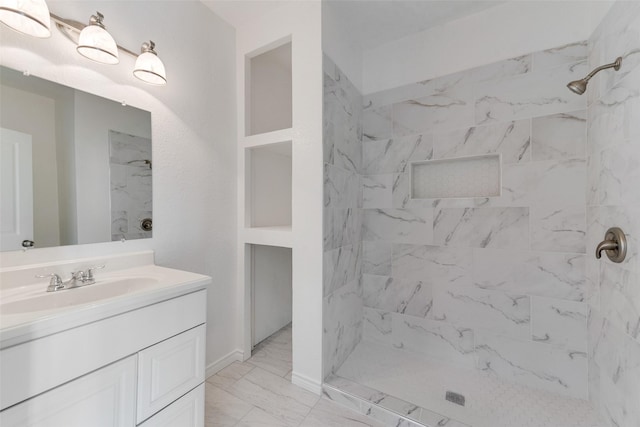 bathroom with vanity and a tile shower