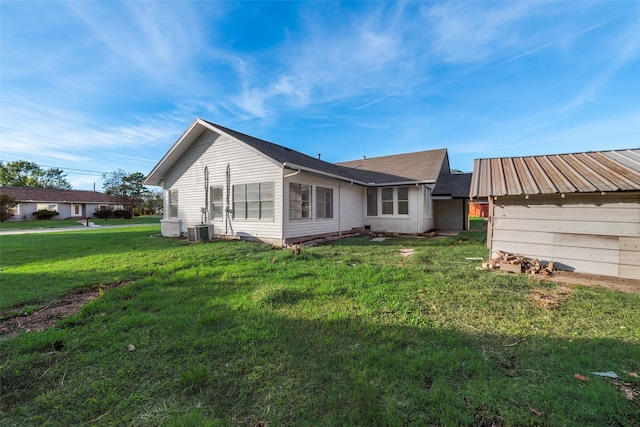 back of house with cooling unit and a yard