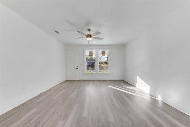 empty room with ceiling fan and light hardwood / wood-style floors