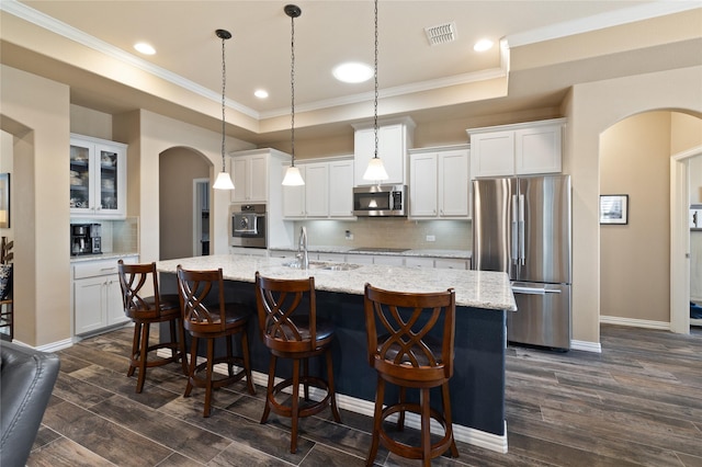 kitchen with sink, appliances with stainless steel finishes, hanging light fixtures, a tray ceiling, and white cabinets