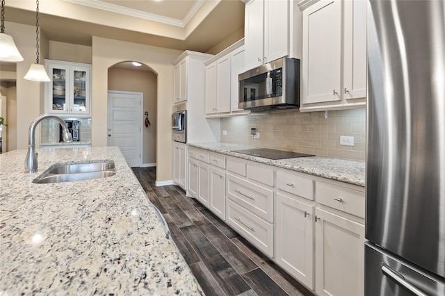 kitchen featuring appliances with stainless steel finishes, decorative light fixtures, sink, white cabinets, and light stone counters