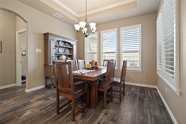 dining space featuring an inviting chandelier, dark hardwood / wood-style flooring, and a tray ceiling