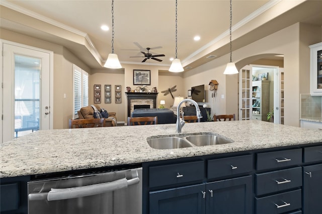 kitchen with sink, dishwasher, a kitchen island with sink, a fireplace, and ornamental molding