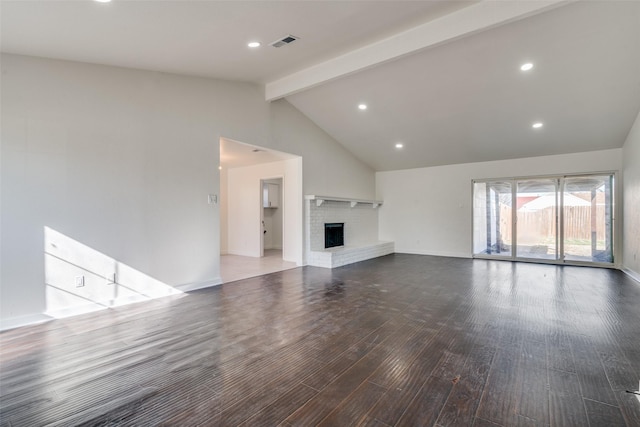 unfurnished living room featuring a fireplace, lofted ceiling with beams, and hardwood / wood-style flooring