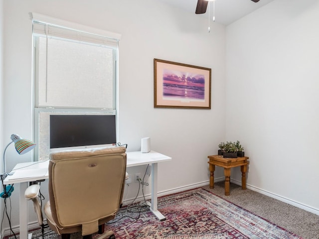 carpeted home office featuring ceiling fan