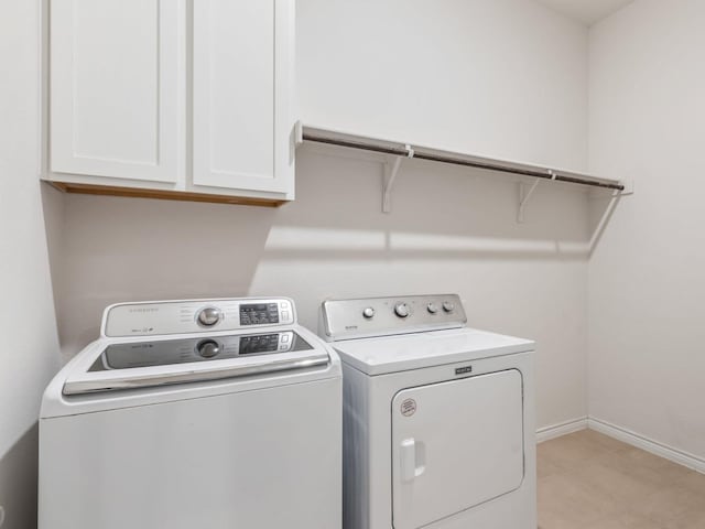 laundry area featuring washer and dryer and cabinets