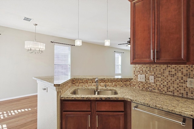 kitchen featuring dishwasher, sink, hanging light fixtures, decorative backsplash, and ceiling fan with notable chandelier