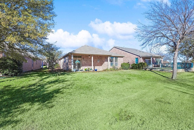 rear view of property featuring a lawn