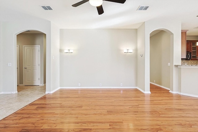 spare room with ceiling fan and light wood-type flooring