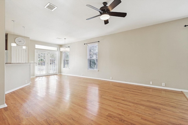 unfurnished living room featuring french doors, light wood-type flooring, and ceiling fan