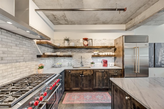 kitchen featuring sink, wall chimney exhaust hood, premium appliances, decorative backsplash, and dark brown cabinets