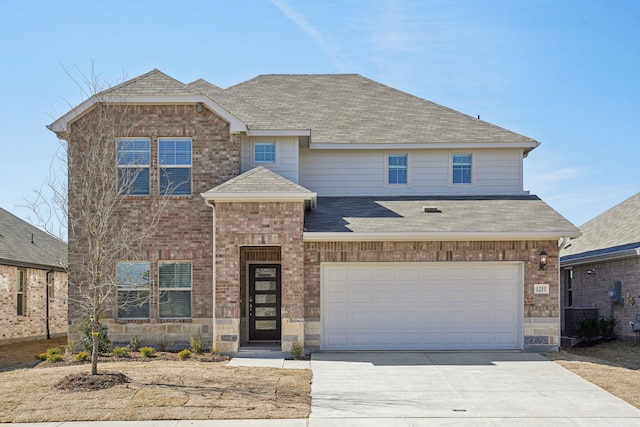 view of front of house featuring a shingled roof, stone siding, brick siding, and driveway