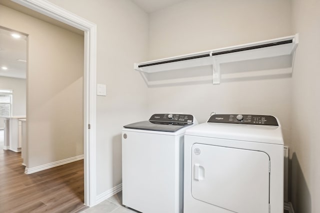 laundry area with washer and dryer and light wood-type flooring