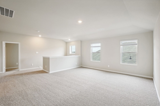 carpeted empty room with vaulted ceiling