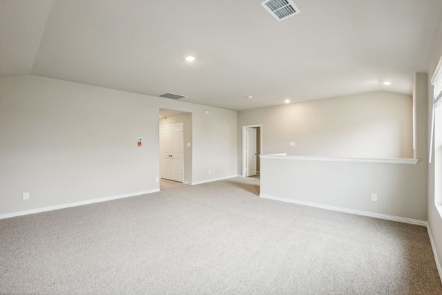 spare room with light carpet and lofted ceiling