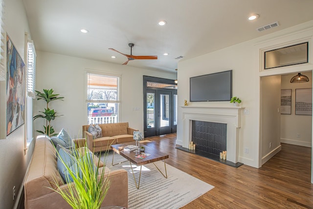 living room with dark wood-type flooring and ceiling fan