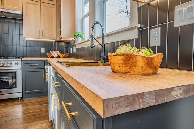 kitchen featuring gray cabinets, sink, butcher block counters, and high end stainless steel range oven