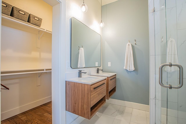 bathroom featuring a shower with door and vanity