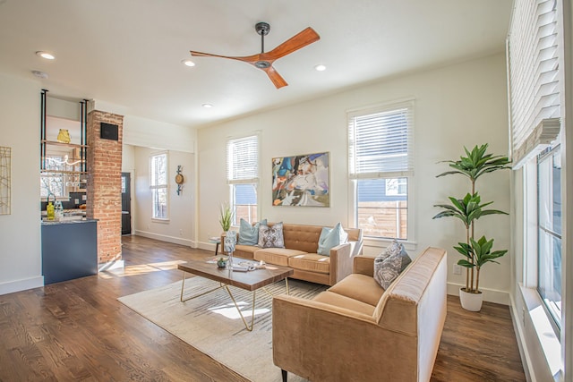 living room featuring dark wood-type flooring and ceiling fan