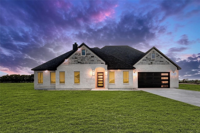 view of front facade with a yard and a garage