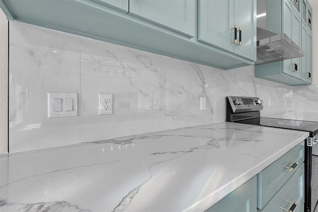 kitchen featuring tasteful backsplash, electric stove, light stone countertops, and wall chimney range hood