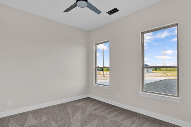 spare room with carpet flooring, ceiling fan, and plenty of natural light