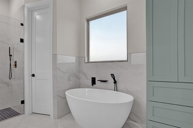 bathroom featuring shower with separate bathtub and tile walls