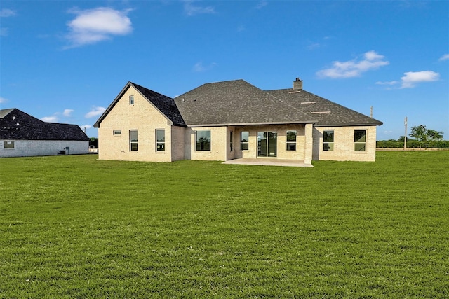 rear view of house with a patio and a lawn