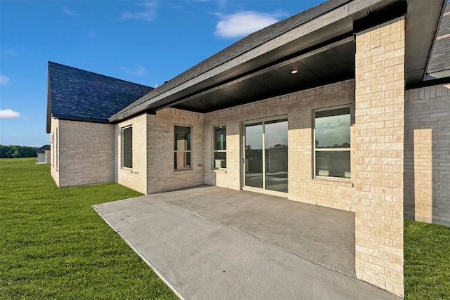 back of house with a lawn and a patio