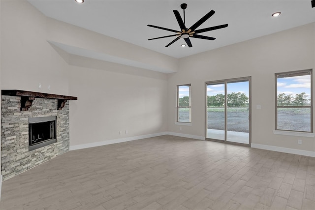 unfurnished living room featuring ceiling fan, a fireplace, and light hardwood / wood-style floors